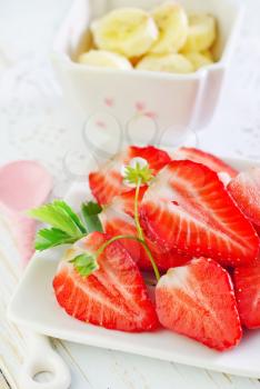 banana and strawberry on plate and on a table