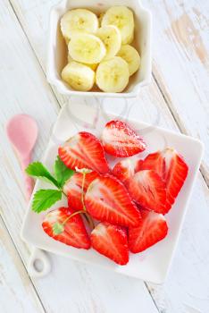 banana and strawberry on plate and on a table