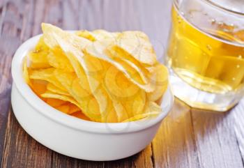 chips from potato with beer on a table