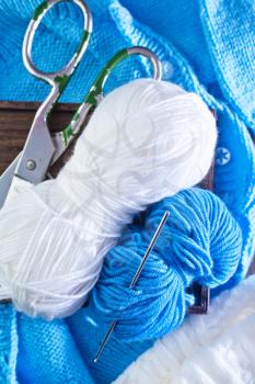 blue threads for knitting on the wooden table