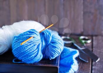 blue threads for knitting on the wooden table
