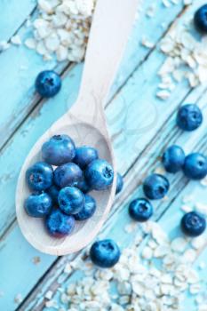 raw oat flakes and fresh blueberry on a table