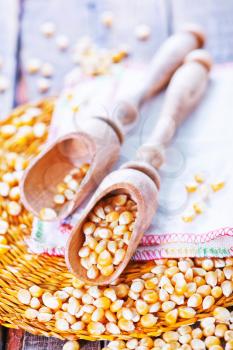 dry corn in wooden spoon and on a table