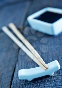 soy sauce and bamboo sticks on a table