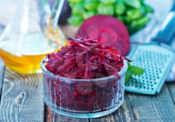 grated beet in bowl and on a table
