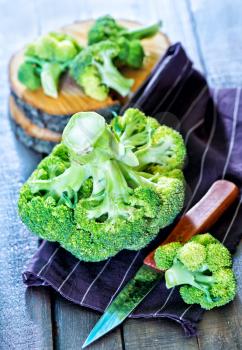 raw brocoli and knife on the wooden background