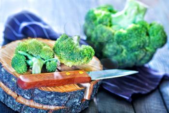 raw brocoli and knife on the wooden background