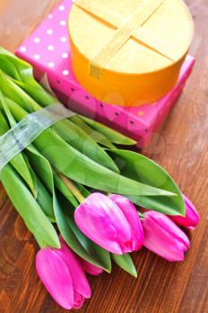 present and tulips on the wooden table