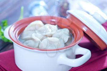 pelmeni with meat in bowl and on a table