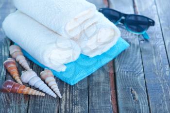 white towels, sea shells and sunglasses on a table