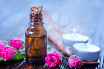 rose oil in bottle and on a table