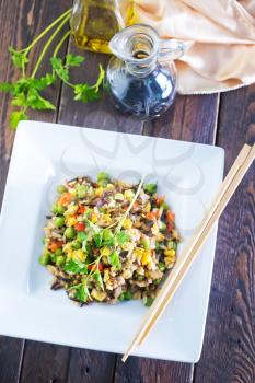 fried rice with vegetables on plate and on a table