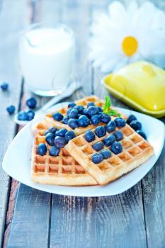 waffle with blueberry on plate and on a table