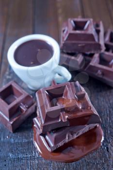 chocolate in cup and on the wooden table