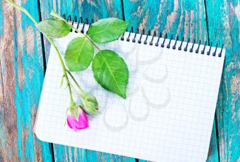 rose and note on the wooden table