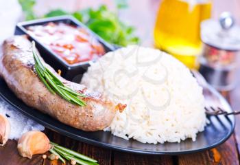 boiled rice with fried sausages on the plate