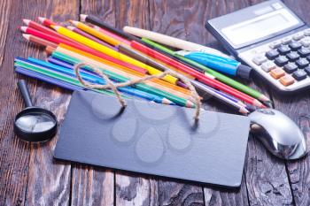school supplies on the wooden table, black board and school supplies