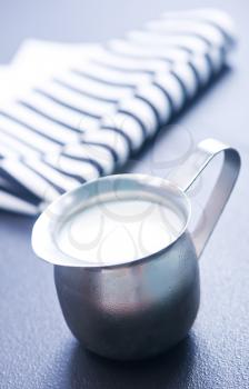 fresh milk in metal jug and on a table