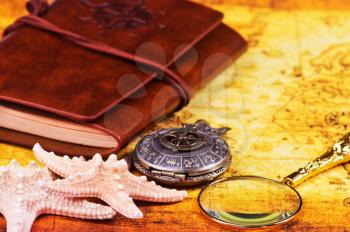 travel background, old notebook, loupe and compass on the map