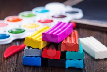 color plasticine on a table, plasticine on wooden background
