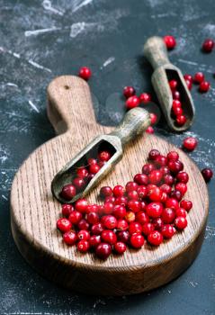 cranberry on wooden board and on a table