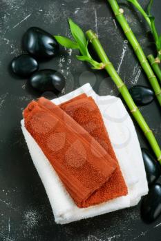 clear towels, black stones and bamboo on a table