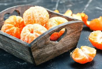 tangerines in wooden box and on a table