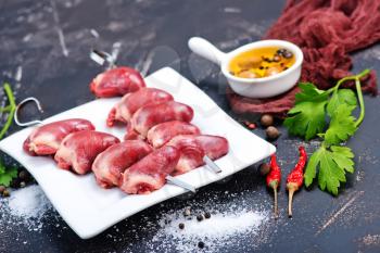 raw duck hearts with spice and salt on a table