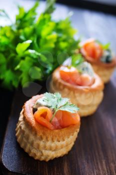 tartalets with salmon and butter on a table