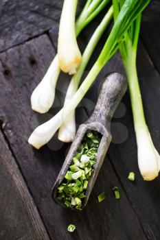 dry green onion and knife on a table