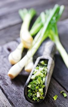 dry green onion and knife on a table