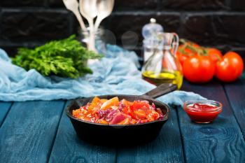 fried vegetables with tomato sauce in the pan