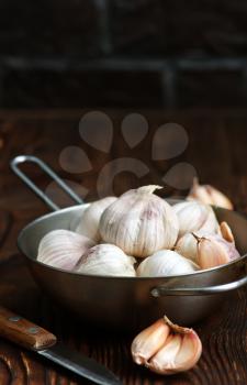 garlic in metal bowl and on a table