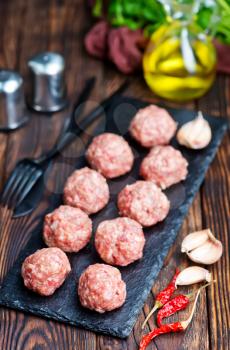raw meat balls with spice on a table