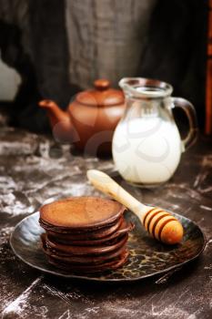 chocolate pancakes on plate and on a table