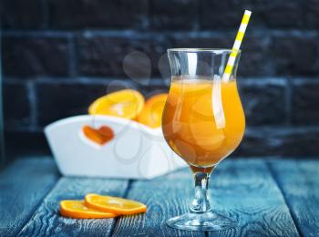 fresh orange juice in glass and on a table