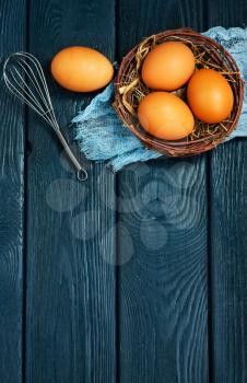 raw chicken eggs in nest and on a table