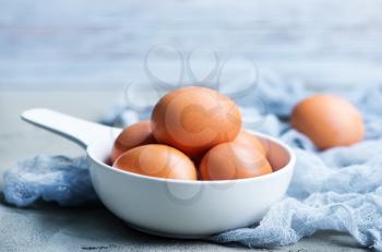 raw eggs in white bowl and on a table