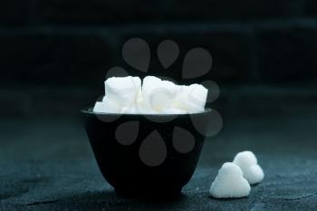 white sugar in bowl and on a table
