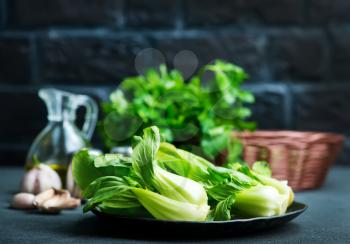 fresh pak choi on plate and on a table