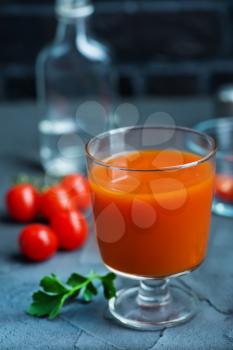 tomato juice in glass and vodka on a table