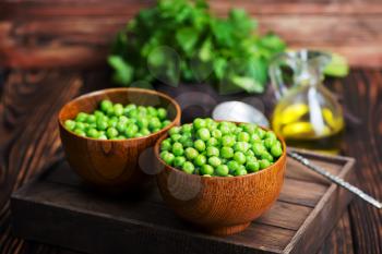 green peas in bowls and on a table