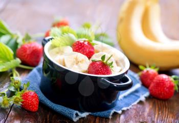 strawberry with bananas in bowl and on a table