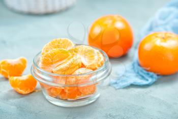 fresh tangerines in bowl and on a table