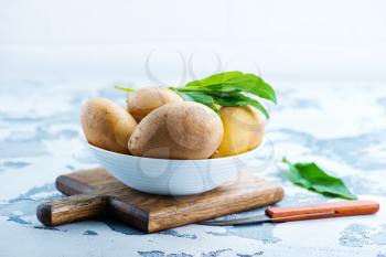 raw potato in bowl and on a table