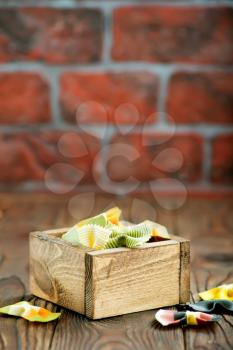 color raw pasta in wooden box and on a table