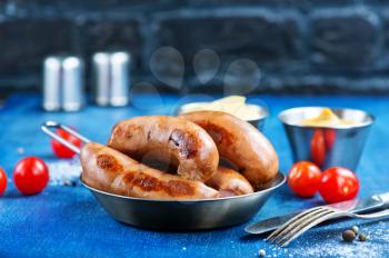 fried sausages in pan and on a table