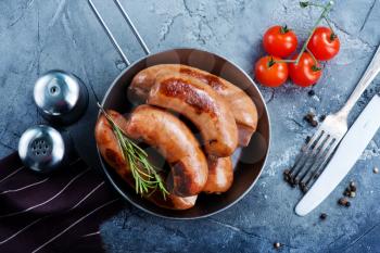 fried sausages in pan and on a table