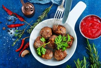 fried meatballs in bowl with spice and sauce