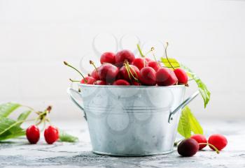 fresh cherry in metal bowl and on a table